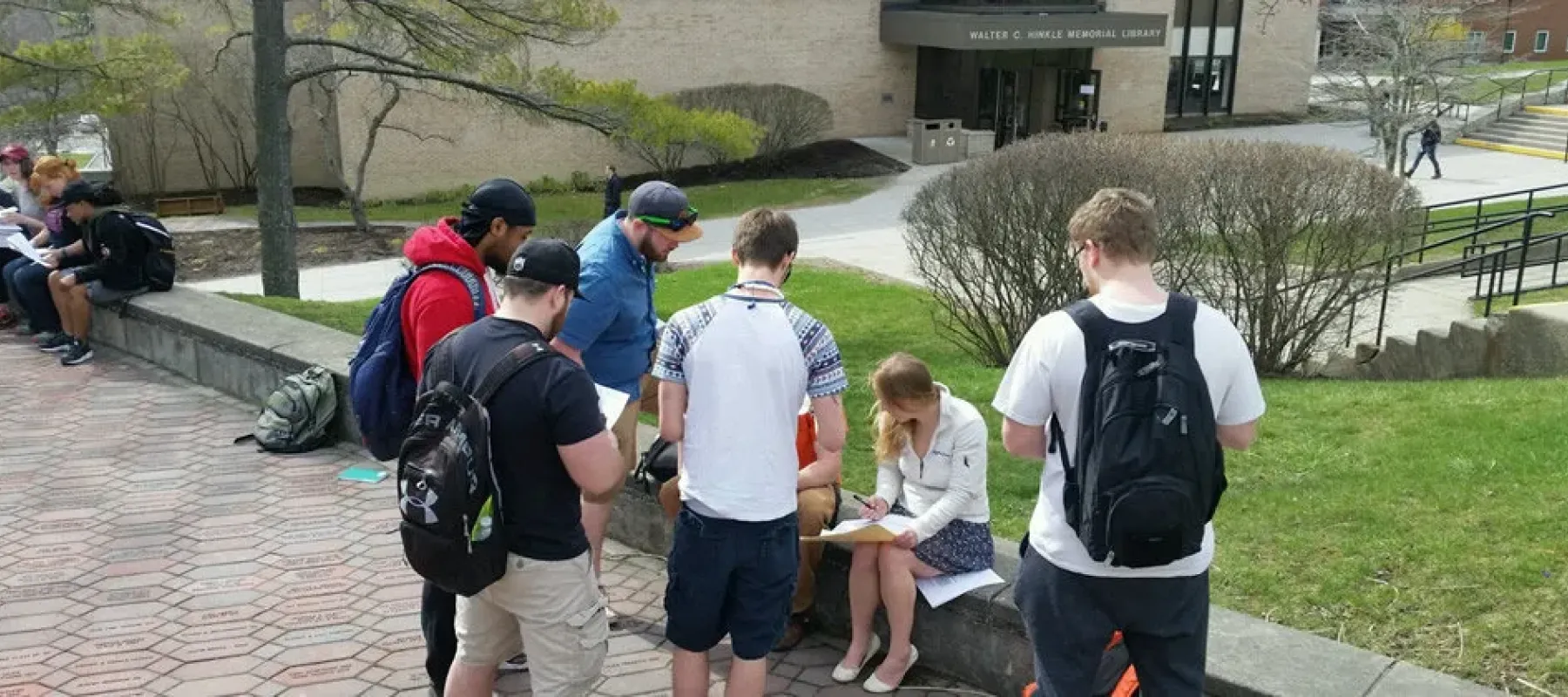 Students on campus outside working on schoolwork.