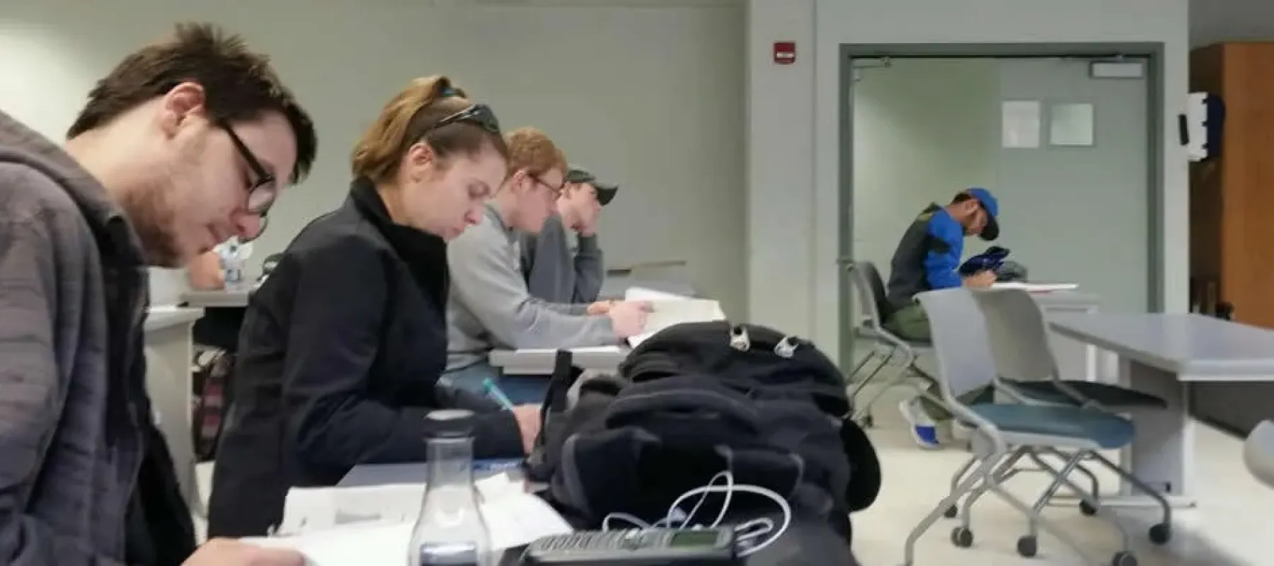 Students sitting at desks in classroom studying.