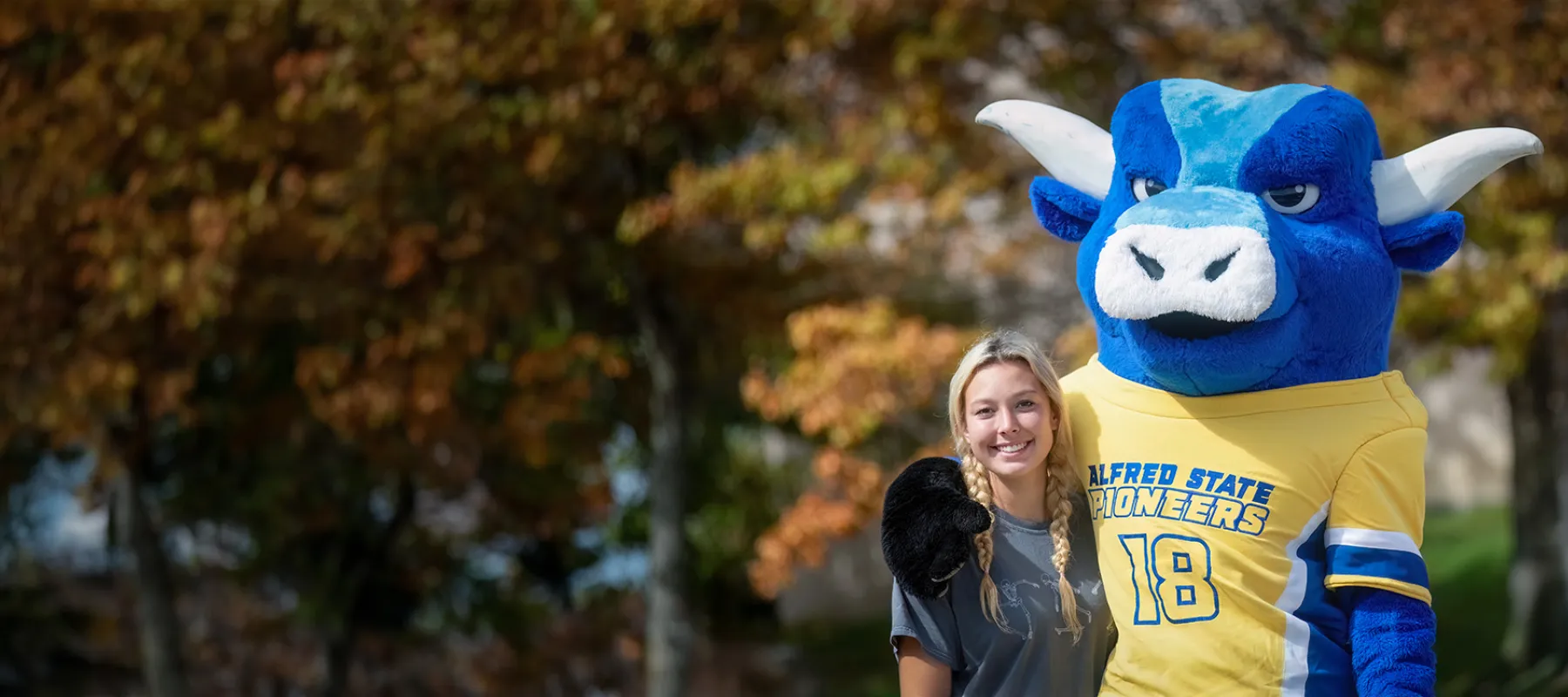 A photo of ASC's mascot Big Blue with a female student.