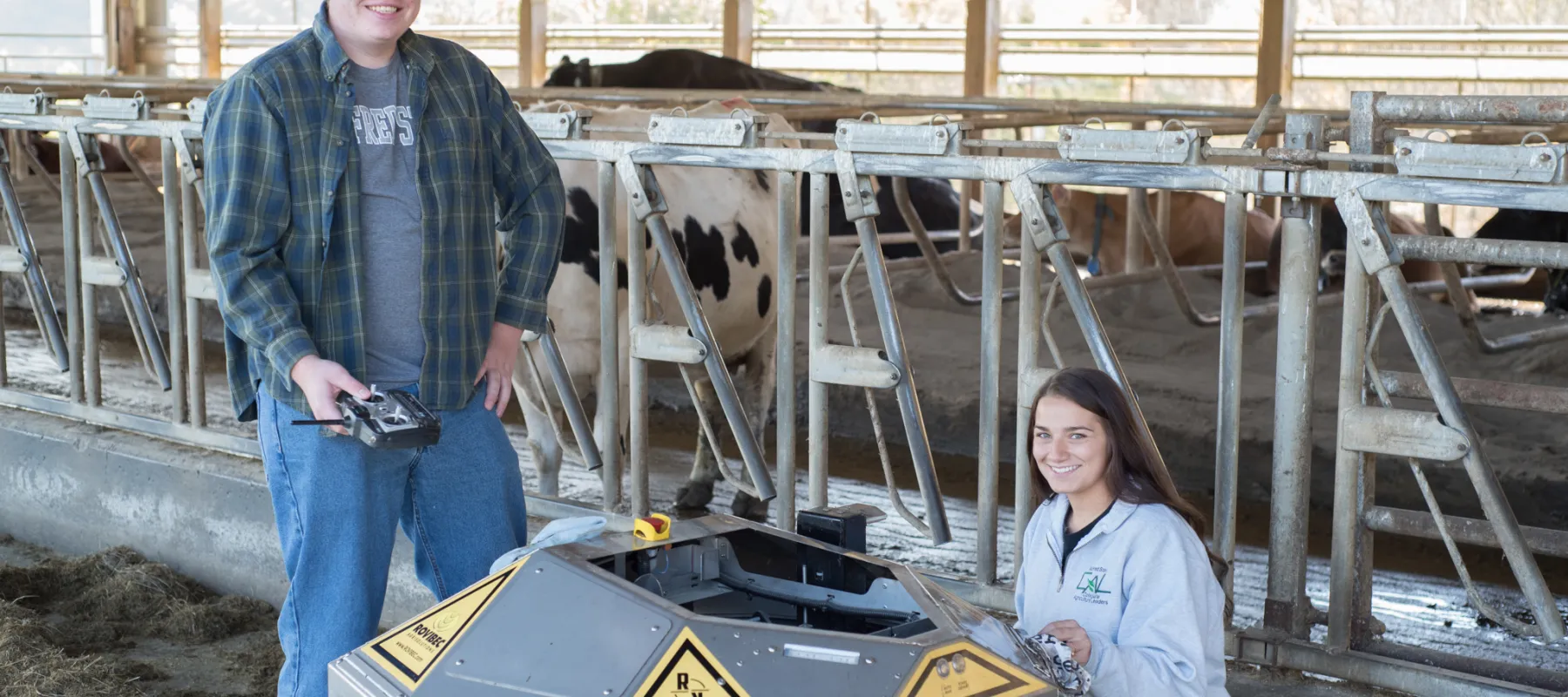 Agricultural Automation and Robotics students posing with equipment and cows in the background.