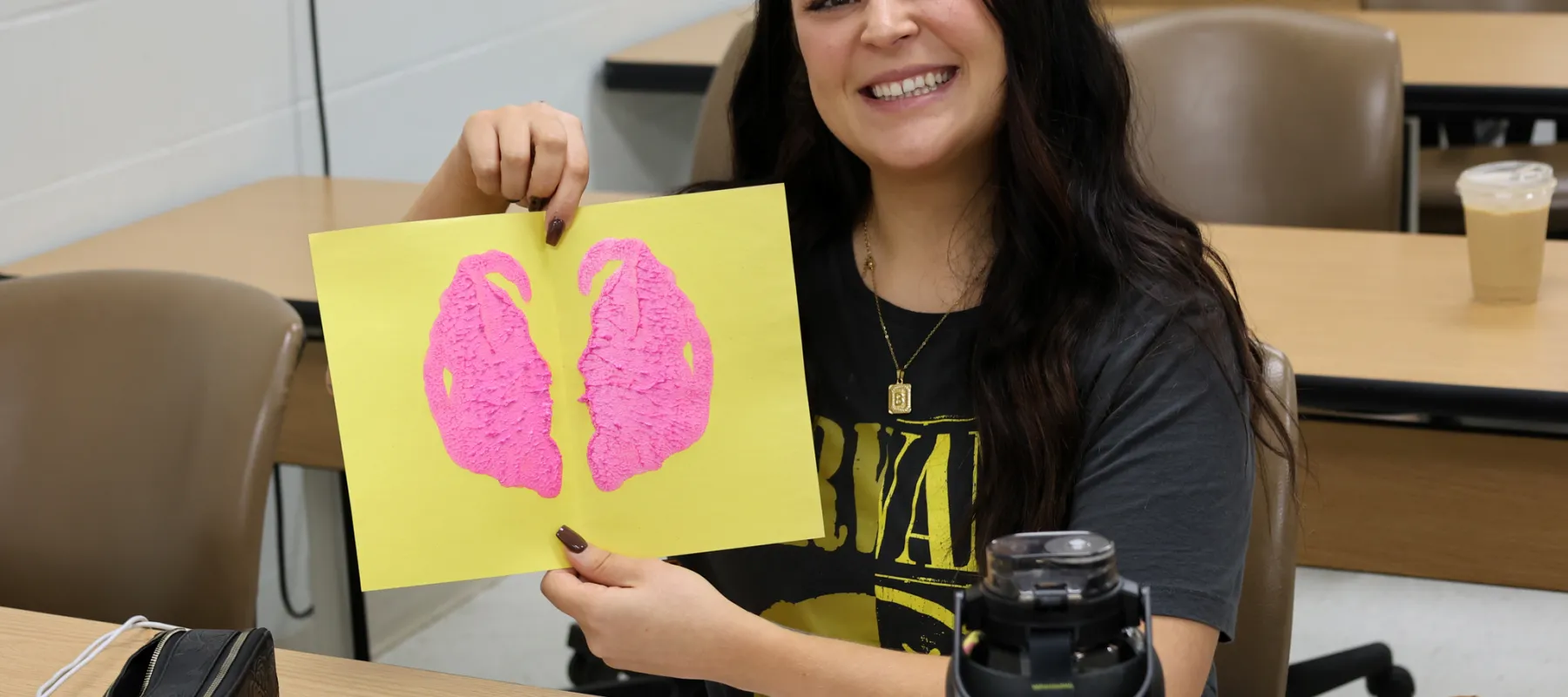 Student posing with artwork.