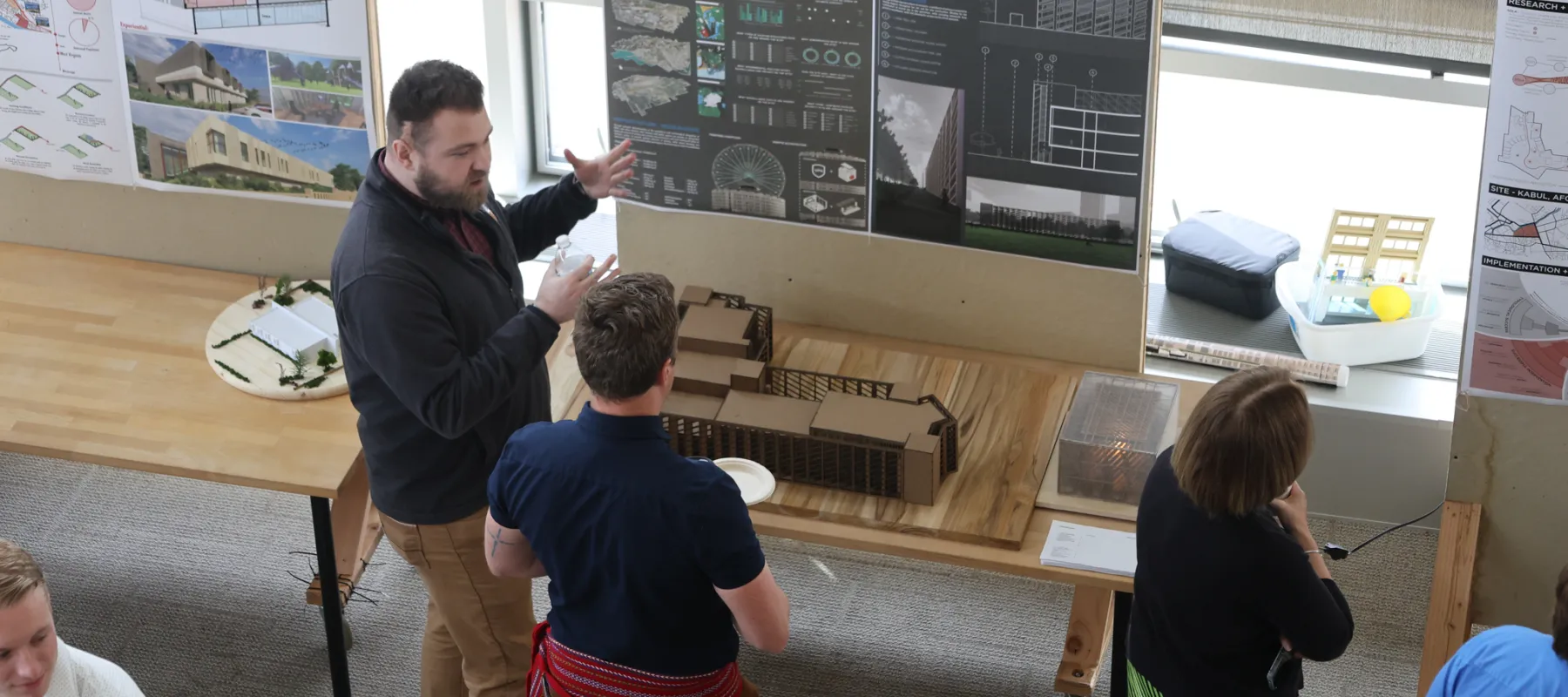 People looking at exhibits of architectural models.