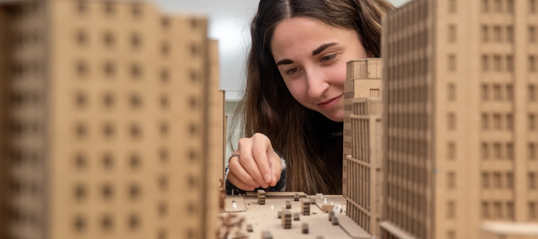 Architecture student working on model of city.
