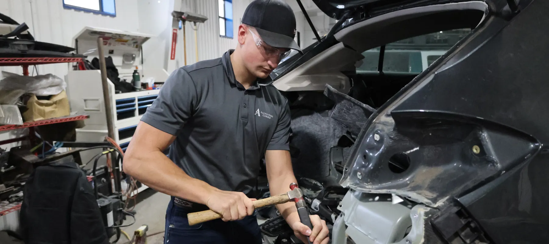 Autobody repair student working on car.