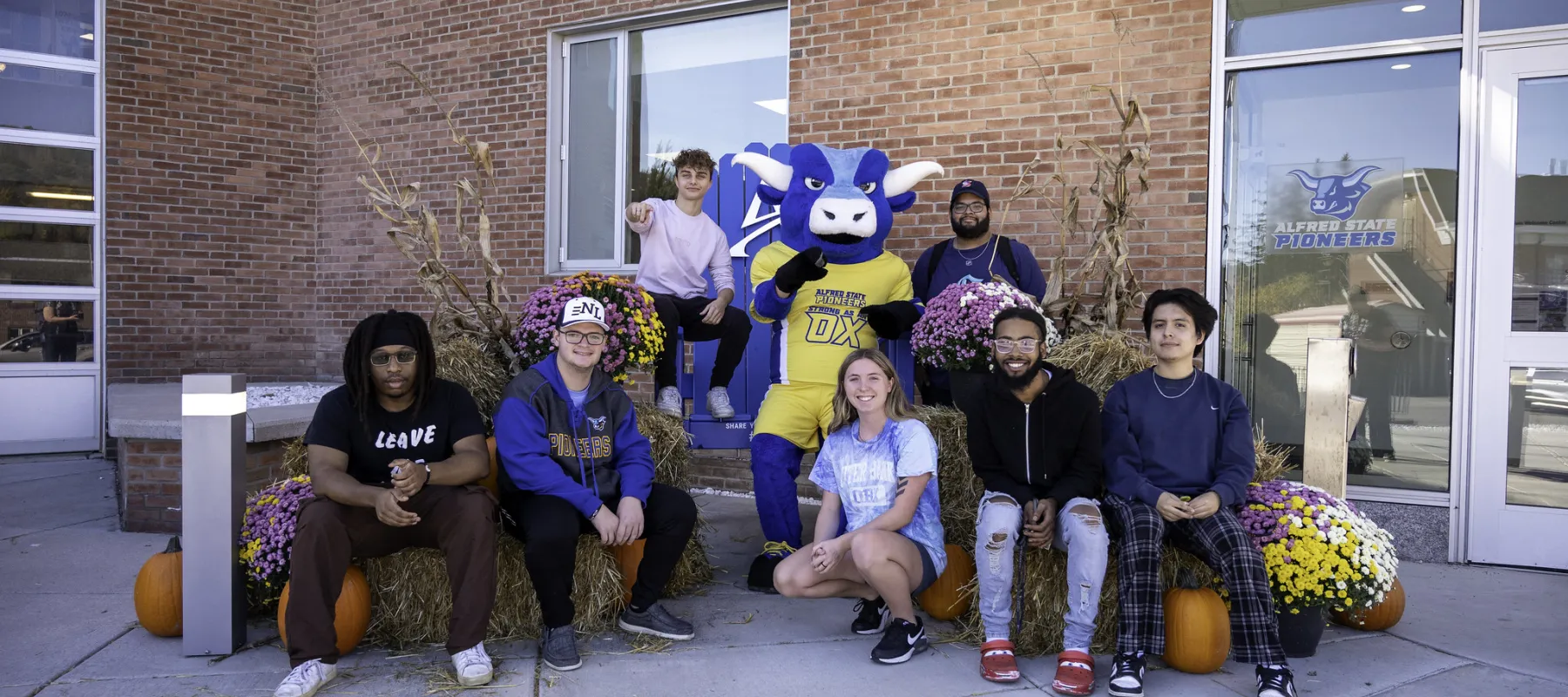 Students sitting with the Alfred State Mascot