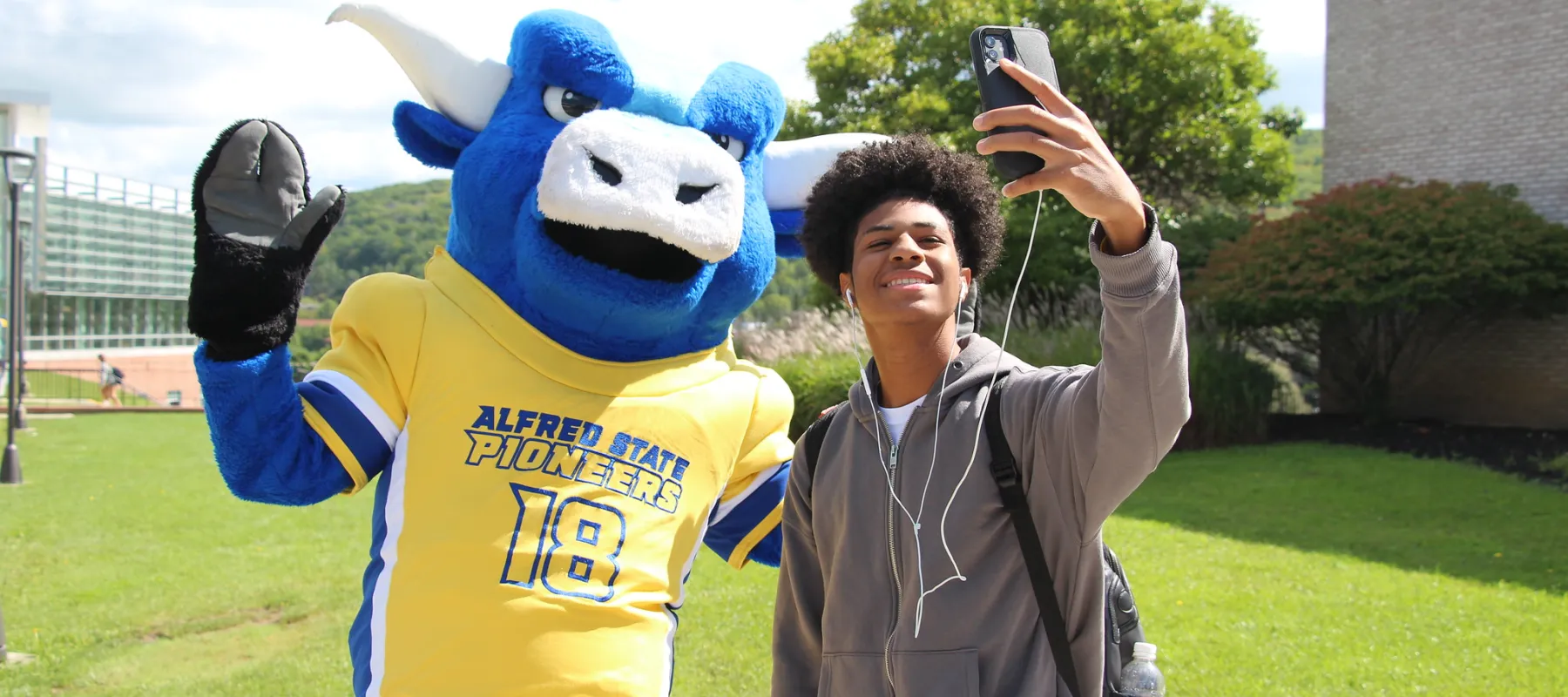 Alfred State's mascot, Big Blue, taking a selfie with a student