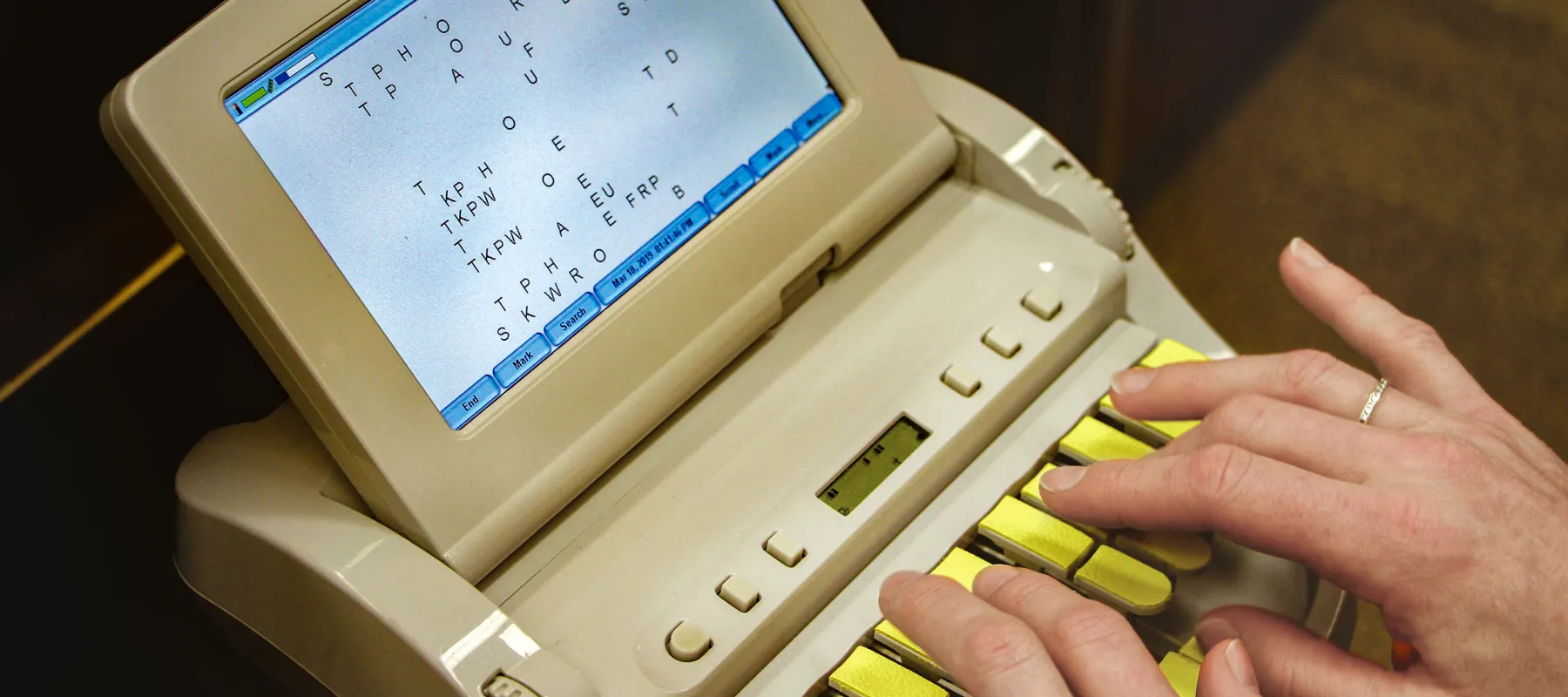 Close up image of someone using a stenotype machine.