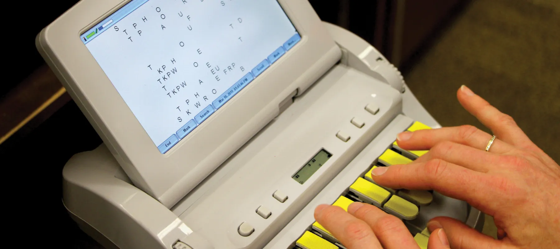 A student typing on a stenokeyboard
