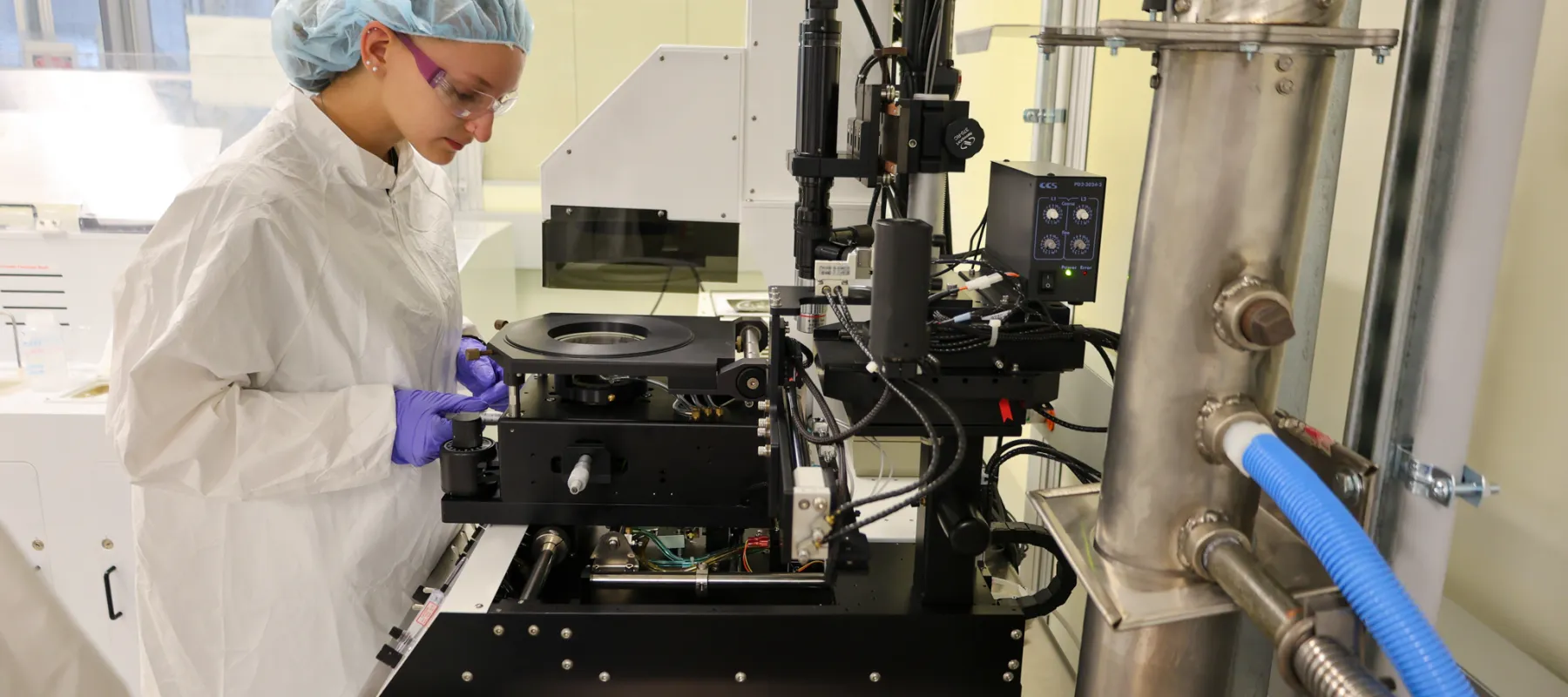 A student working on equipment in the electrical engineering technology cleanroom.