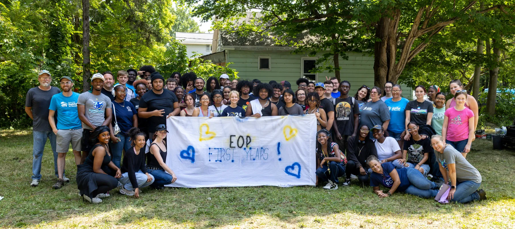 A large group of students outdoors holding a banner that says "EOP First Years."