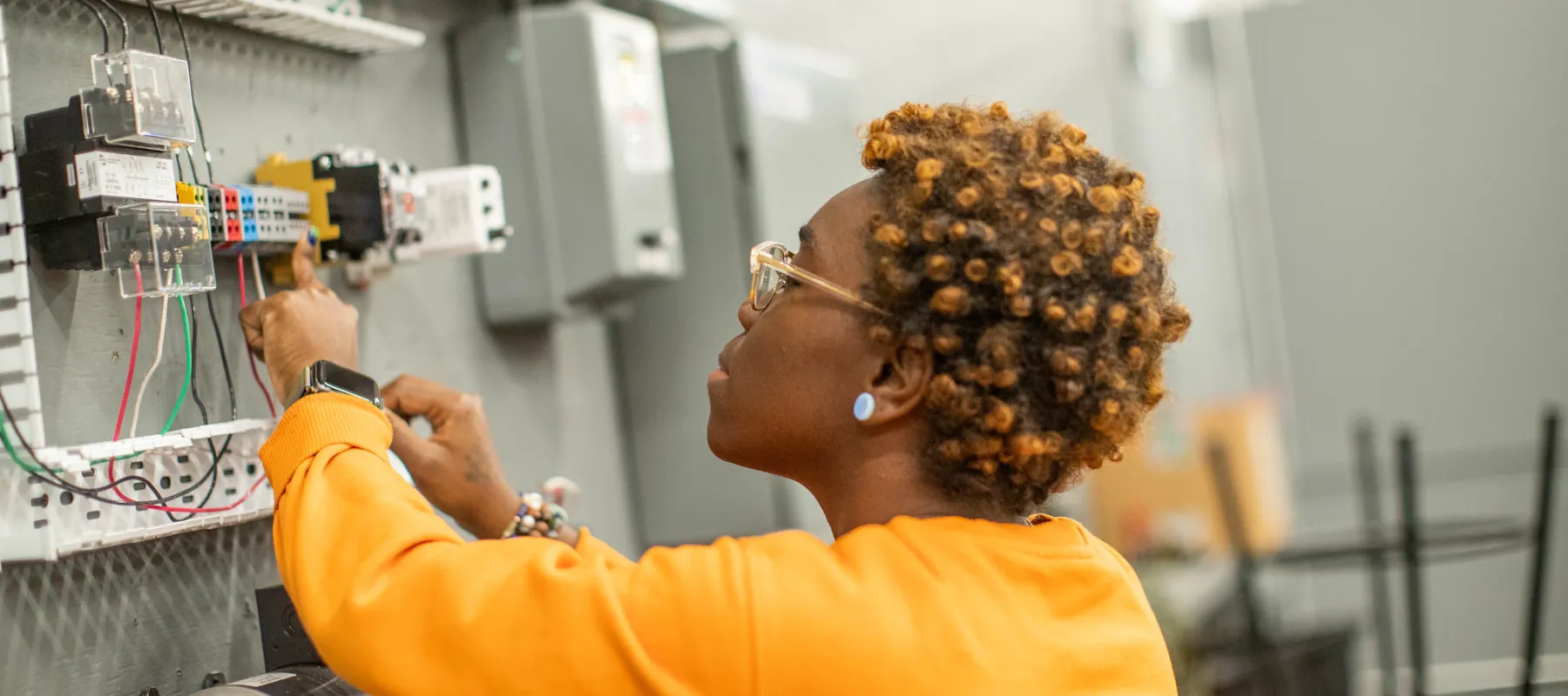 A student working on electrical equipment.
