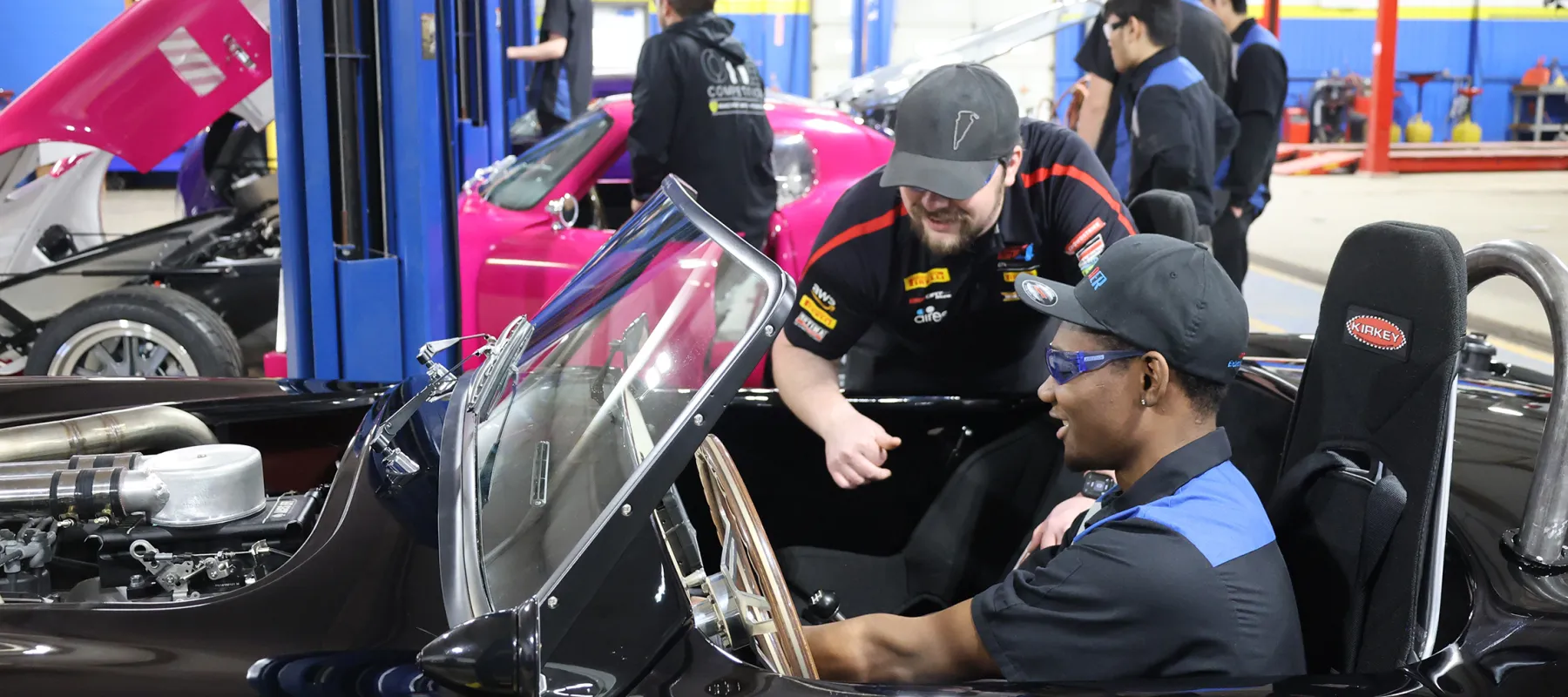 Instructor with student working on a car