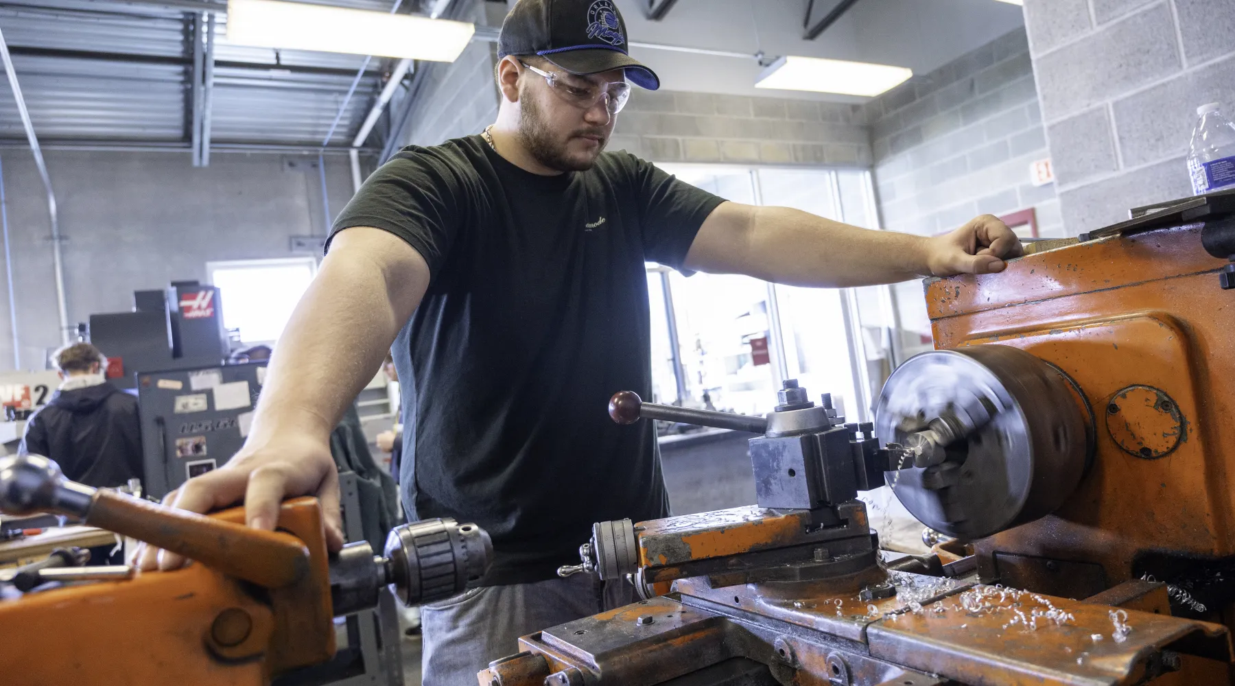 A student working on a metal lathe