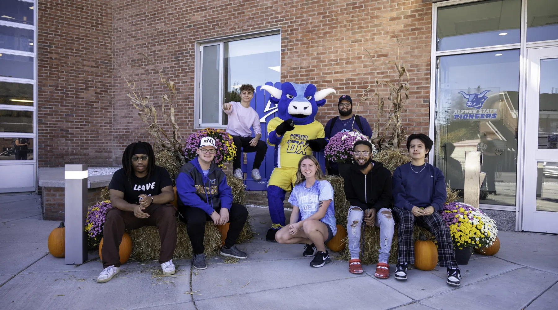 Students sitting with the Alfred State Mascot