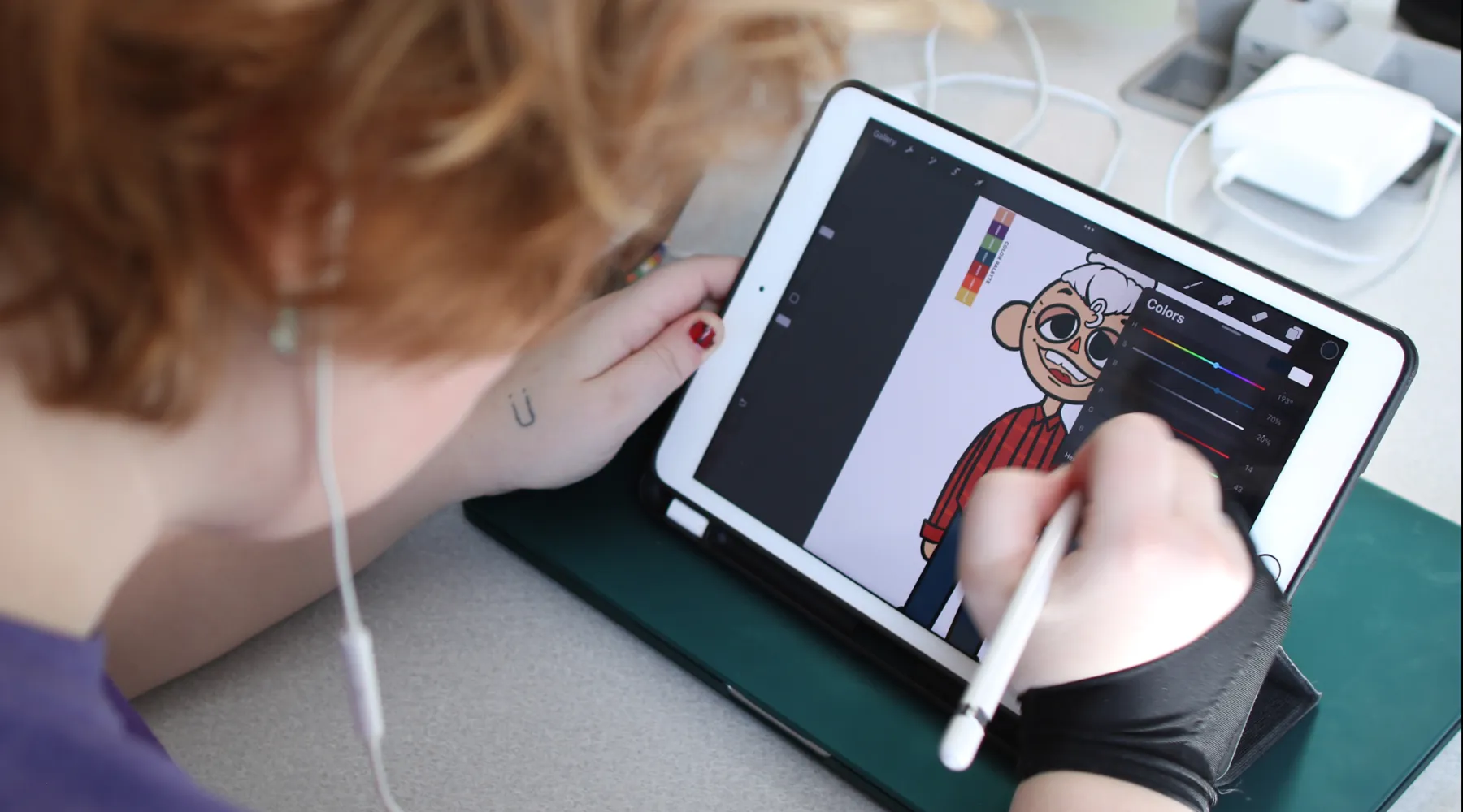 A student working on a digital tablet drawing a character.