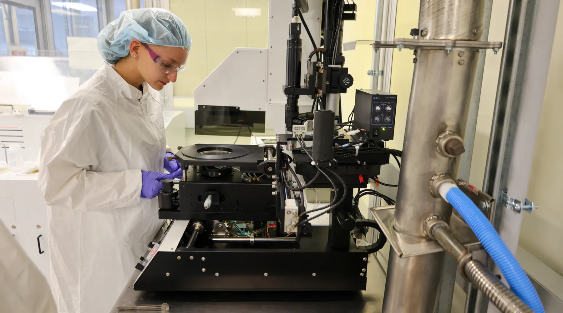 A student working on equipment in the electrical engineering technology cleanroom.