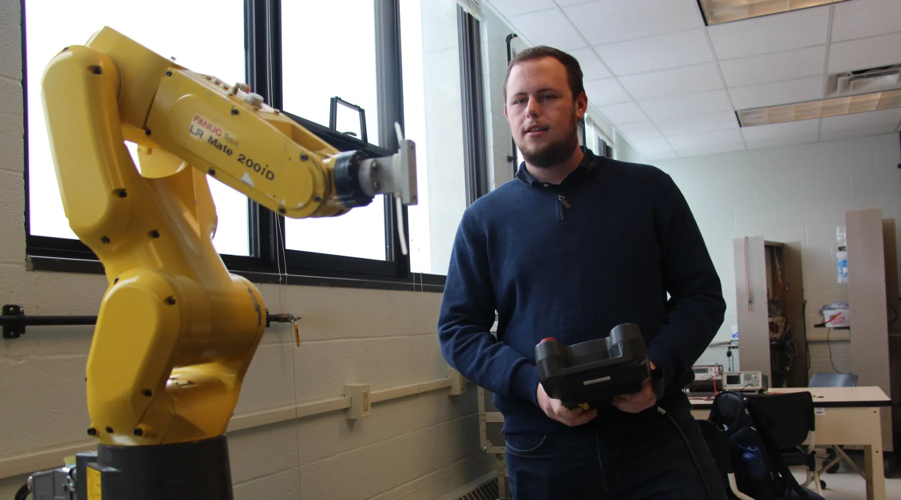 A professor working with a robotic arm
