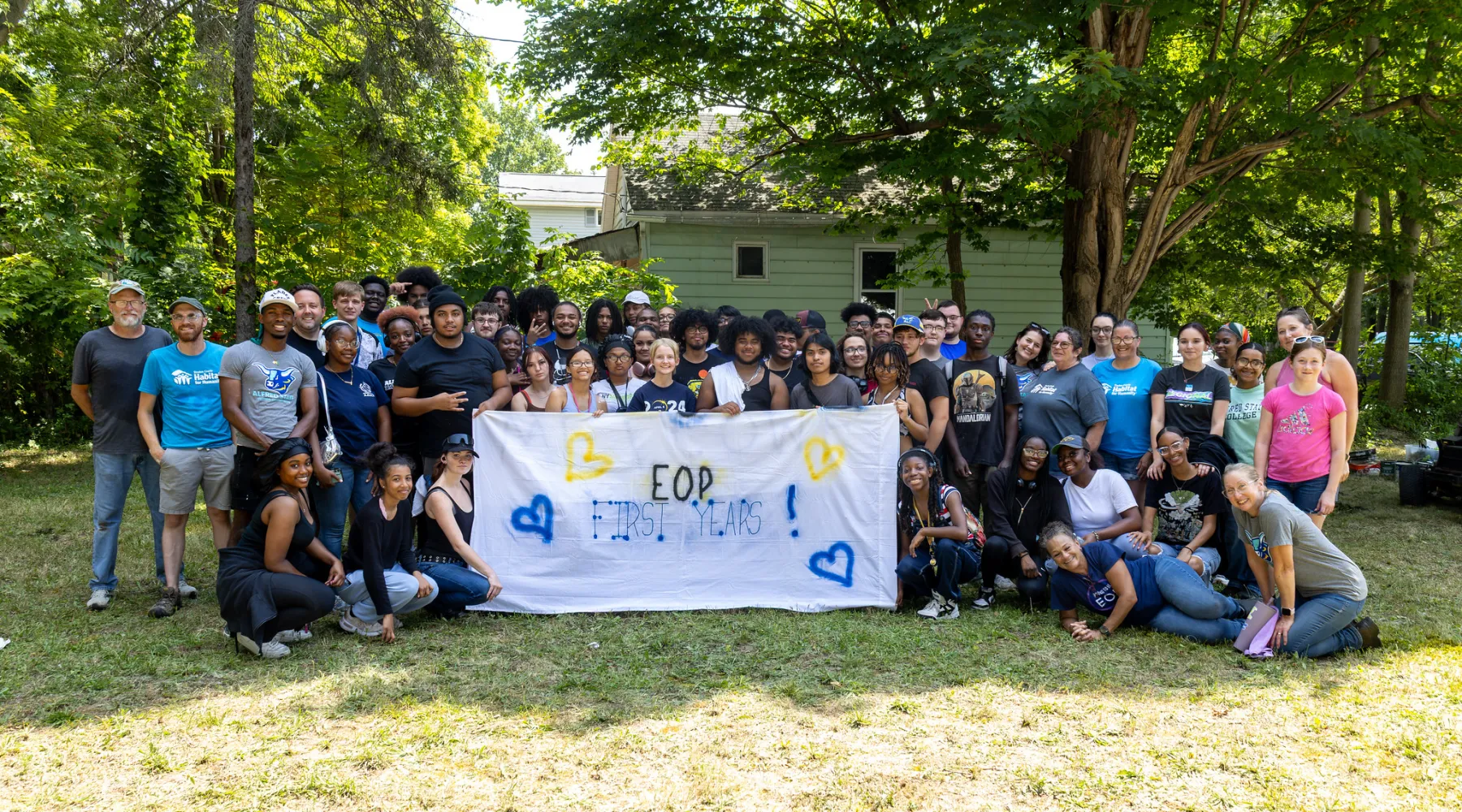 A large group of students outdoors holding a banner that says "EOP First Years."