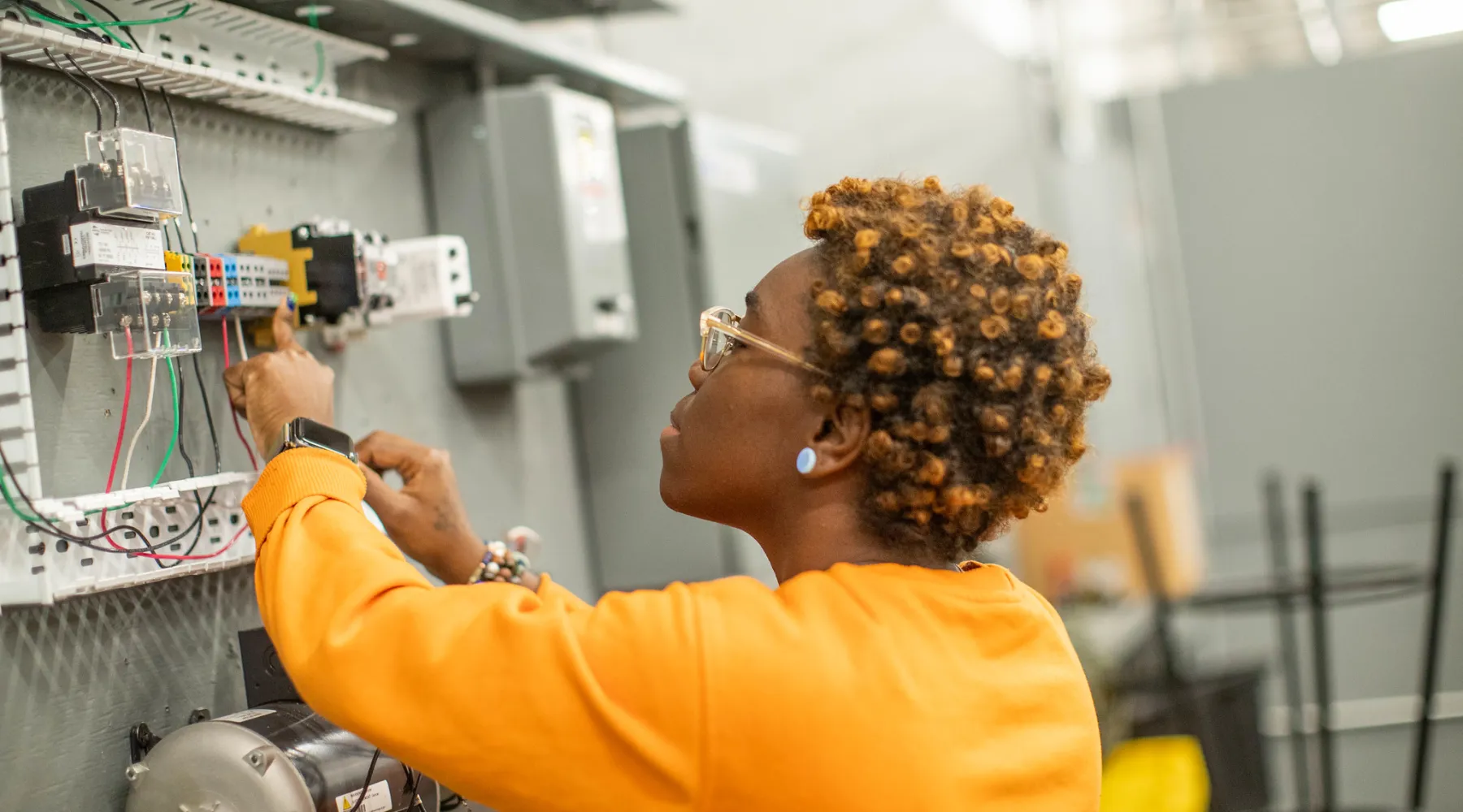 A student working on electrical equipment.