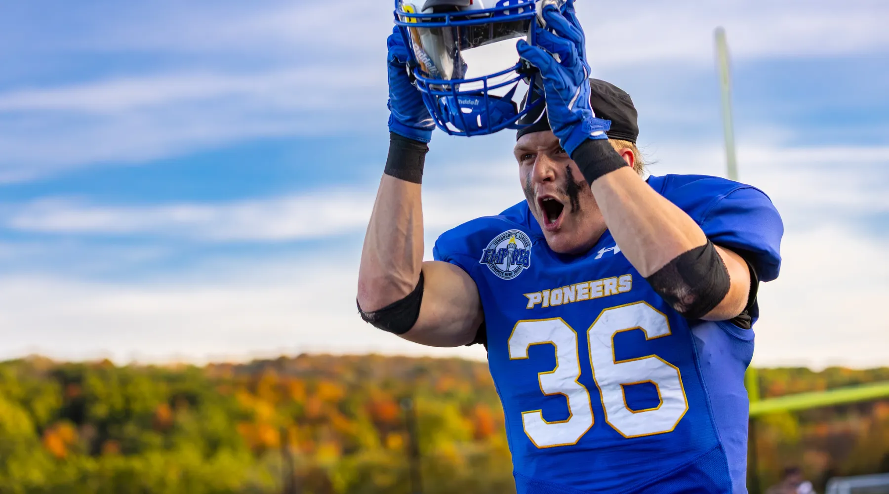 A football player taking off his helmet.