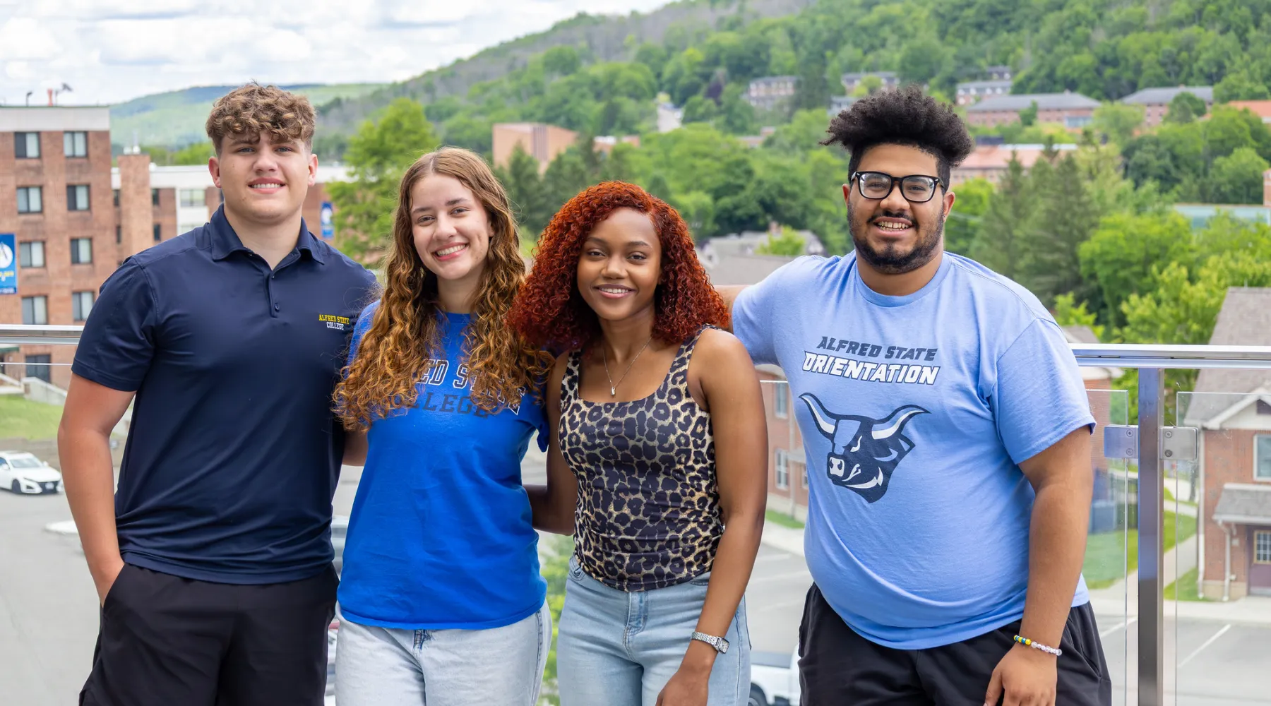 Four students standing on a balcony.