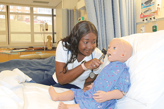 student with a doll in a lab